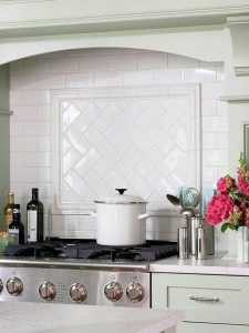 Subway tile backsplash with herringbone pattern behind stove top