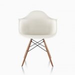 White Eames Molded Plastic armchair with dowel legs, viewed from the