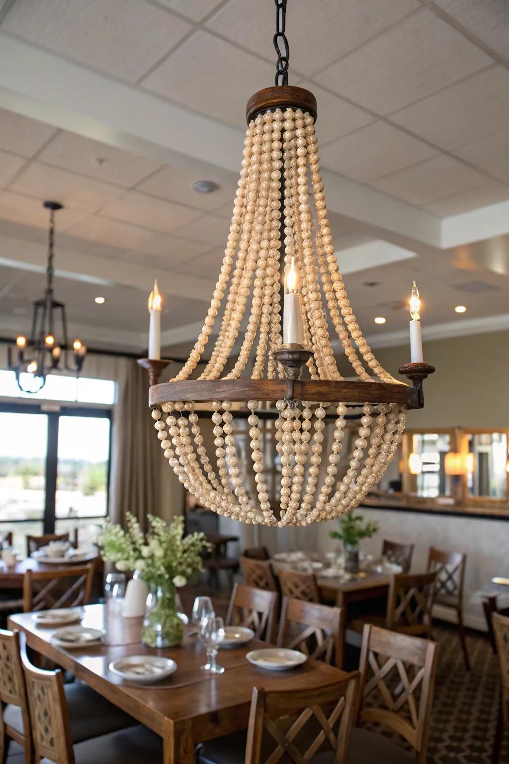 Chandelier decorated with wooden bead garland for boho farmhouse style.